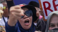 Tampak massa berteriak saat demonstrasi.