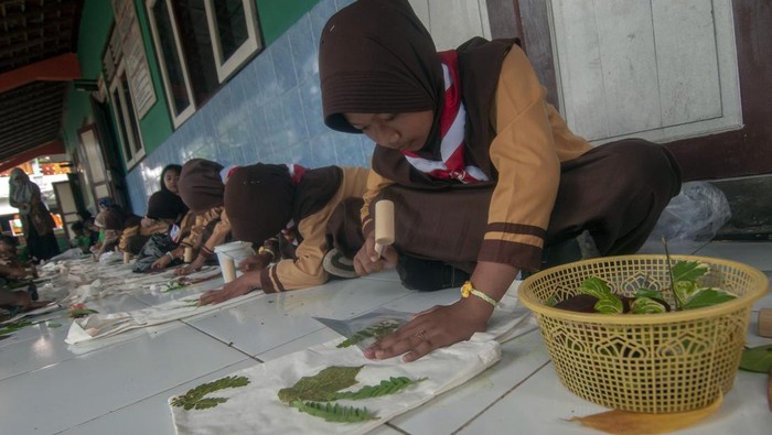 Sejumlah siswa memukul daun pada kain tas saat belajar seni ecoprint di Sekolah Dasar Negeri 2 Gumukrejo, Boyolali, Jawa Tengah, Sabtu (2/3/2024). kegiatan belajar seni ecoprint tersebut untuk melatih kreativitas dan motorik serta mengajak siswa dapat memanfaatkan bahan daun dari sekitar menjadi barang yang memiliki nilai seni dan ekonomi. ANTARA FOTO/Aloysius Jarot Nugroho/wpa.