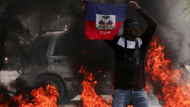 A demonstrator holds up a Haitian flag during a protest against Prime Minister Ariel Henry's government and insecurity, in Port-au-Prince, Haiti March 1, 2024. REUTERS/Ralph Tedy Erol/File Photo Purchase Licensing Rights