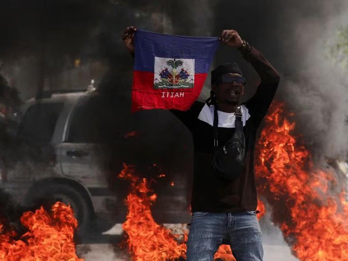 A demonstrator holds up a Haitian flag during a protest against Prime Minister Ariel Henrys government and insecurity, in Port-au-Prince, Haiti March 1, 2024. REUTERS/Ralph Tedy Erol/File Photo Purchase Licensing Rights