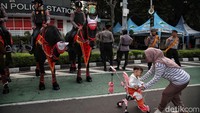 Polisi berkuda yang bersiaga di kawasan tersebut pun menjadi primadona. Banyak warga yang antusias berfoto-ria bersama mereka.