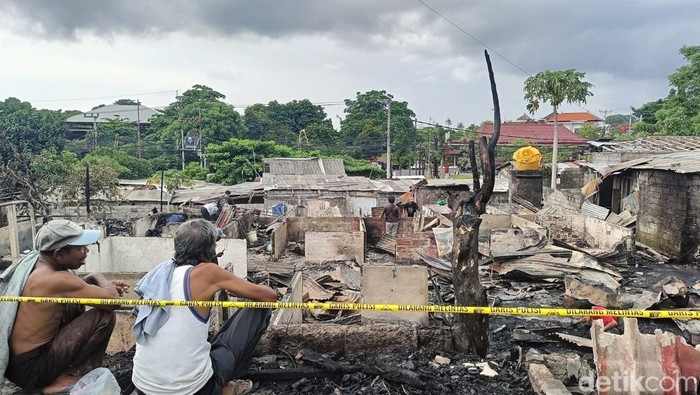 Dua pria memandangi puing-puing 29 kamar kos yang terbakar di Kesiman Kertalangu, Denpasar, Minggu (3/3/2024) siang.
