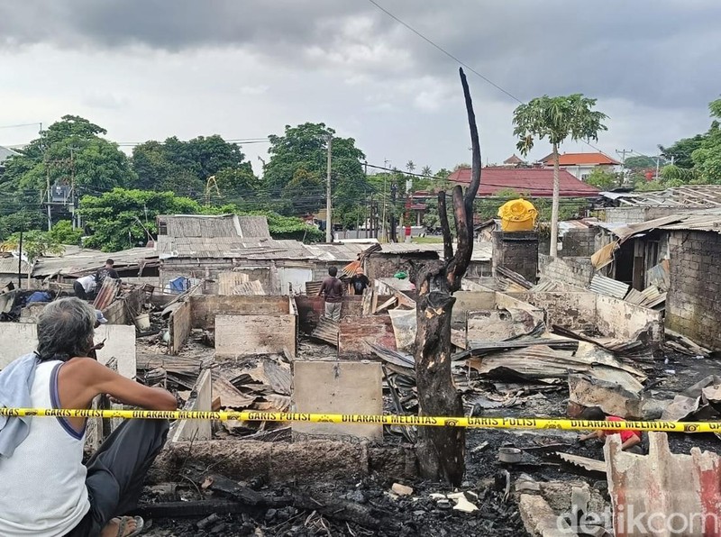 Dua pria memandangi puing-puing 29 kamar kos yang terbakar di Kesiman Kertalangu, Denpasar, Minggu (3/3/2024) siang.