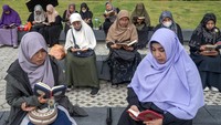 Sejumlah perempuan muslim bersama-sama membaca Alquran pada kegiatan Palu Bertilawah di Taman Nasional, Palu, Sulawesi Tengah, Minggu (3/3/2024). 