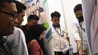 Penjaga stan perusahaan memberikan informasi kepada pencari kerja di Pusat Perbelanjaan di Medan Satria, Bekasi, Jawa Barat, Senin (4/3/2023).
