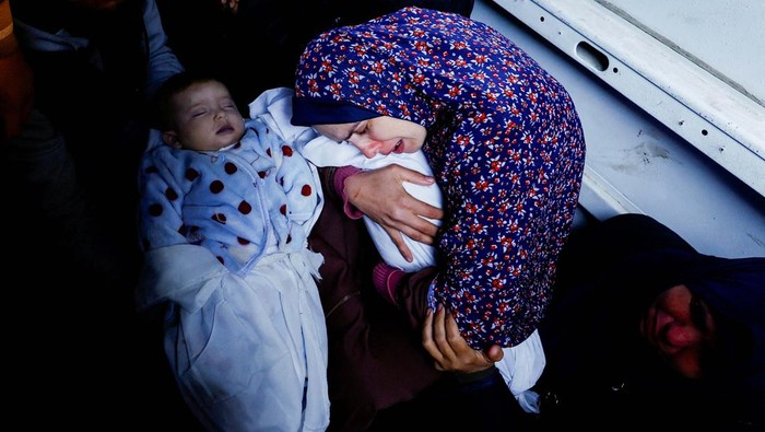 Duka Ibu yang Kehilangan Bayi Kembar Akibat Serangan Israel A mourner reacts during the funeral of the Palestinian twins Wesam and Naeem Abu Anza, who were born during the conflict between Israel and Hamas and were killed in Israeli air strikes, in Rafah in the southern Gaza Strip March 3, 2024. REUTERS/Mohammed Salem