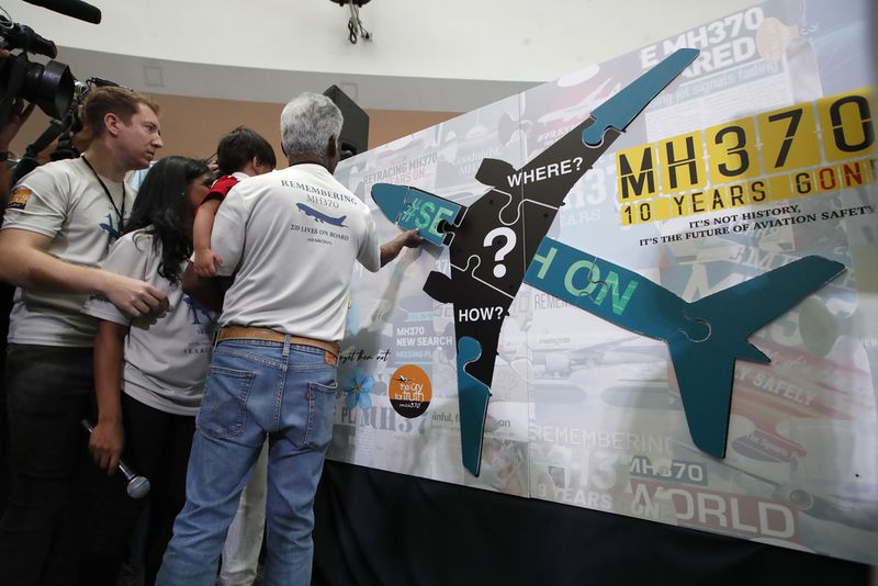 A woman writes well messages on the message board during the tenth annual remembrance event at a shopping mall, in Subang Jaya, on the outskirts of Kuala Lumpur, Malaysia, Sunday, March 3, 2024. Ten years ago, a Malaysia Airlines Flight 370, had disappeared March 8, 2014 while en route from Kuala Lumpur to Beijing with over 200 people on board. (AP Photo/FL Wong)