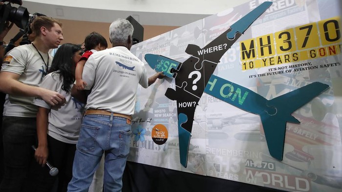 A woman writes well messages on the message board during the tenth annual remembrance event at a shopping mall, in Subang Jaya, on the outskirts of Kuala Lumpur, Malaysia, Sunday, March 3, 2024. Ten years ago, a Malaysia Airlines Flight 370, had disappeared March 8, 2014 while en route from Kuala Lumpur to Beijing with over 200 people on board. (AP Photo/FL Wong)