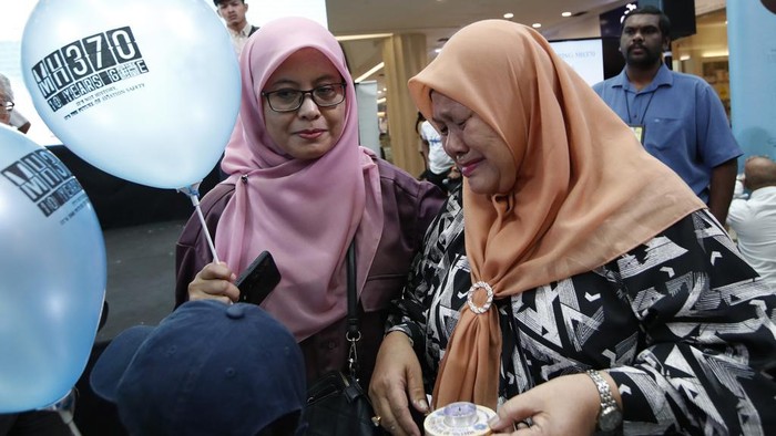 A woman writes well messages on the message board during the tenth annual remembrance event at a shopping mall, in Subang Jaya, on the outskirts of Kuala Lumpur, Malaysia, Sunday, March 3, 2024. Ten years ago, a Malaysia Airlines Flight 370, had disappeared March 8, 2014 while en route from Kuala Lumpur to Beijing with over 200 people on board. (AP Photo/FL Wong)