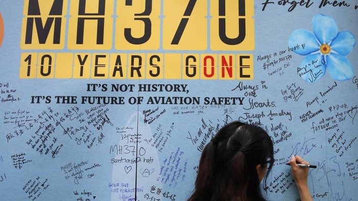 A woman writes well messages on the message board during the tenth annual remembrance event at a shopping mall, in Subang Jaya, on the outskirts of Kuala Lumpur, Malaysia, Sunday, March 3, 2024. Ten years ago, a Malaysia Airlines Flight 370, had disappeared March 8, 2014 while en route from Kuala Lumpur to Beijing with over 200 people on board. (AP Photo/FL Wong)