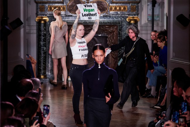 Saat model memamerkan busana untuk musim dingin/gugur karya Victoria, beberapa demonstran tiba-tiba ikut eksis di catwalk. Foto: REUTERS/Gonzalo Fuentes