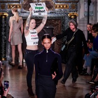 Saat model memamerkan busana untuk musim dingin/gugur karya Victoria, beberapa demonstran tiba-tiba ikut eksis di catwalk. Foto: REUTERS/Gonzalo Fuentes