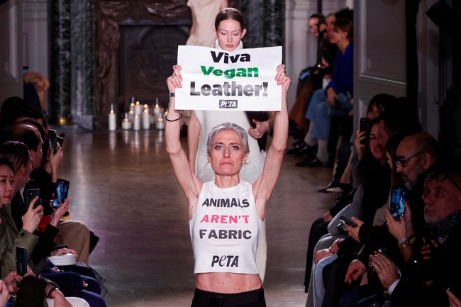 Para pendemo membawa tulisan yang menyuarakan agar brand-brand termasuk Victoria Beckham setop memakai kulit binatang. “Viva vegan leather!” dan “Animals aren’t fabric” adalah dua kalimat yang ditulis pendemo dalam poster yang mereka bawa. Foto: REUTERS/Gonzalo Fuentes