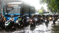 Arus lalu lintas tampak merayap. Hal itu disebabkan oleh pengendara yang melambatkan laju kendaraan saat melintasi genangan.