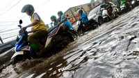 Ketinggian air yang mencapai 20 cm membuat pengendara memperlambat kecepatan.