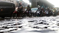 Para pengendara menerobos genangan di depan asar Induk Kramat Jati, Jakarta Timur.