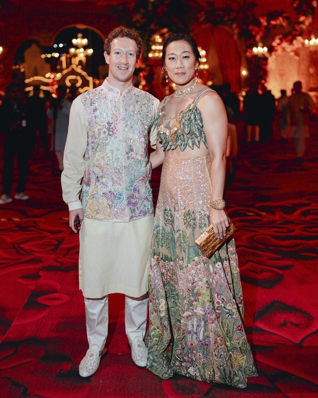 Mark Zuckerberg memilih kurta, blouse panjang mirip baju koko dengan vest berwarna cerah penuh bordiran bernuansa fauna. Istrinya, Priscilla, mengenakan busana lehenga dengan detail atraktif. Bordiran yang menggambarkan keindahan alam flora dan fauna membuat penampilannya mencuri perhatian. Foto: Reliance group via AP