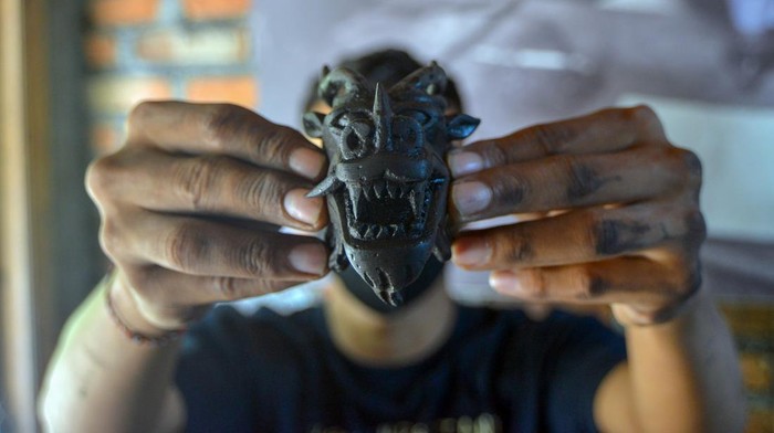 Perajin menunjukan miniatur kepala naga berbahan batu bara di industri rumahan SP Special kota Sawahlunto, Sumatera Barat, Senin (4/3/2024). Kerajinan batu bara binaan PT Bukit Asam Tbk itu dijual mulai harga ratusan ribu hingga jutaan rupiah per buah ke luar negeri seperti Jepang, Cina, Malaysia, dan Jerman.  ANTARA FOTO/Iggoy el Fitra/nym.