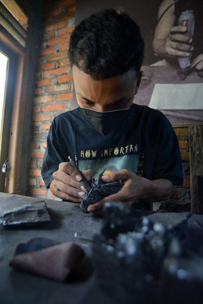Perajin menunjukan miniatur kepala naga berbahan batu bara di industri rumahan SP Special kota Sawahlunto, Sumatera Barat, Senin (4/3/2024). Kerajinan batu bara binaan PT Bukit Asam Tbk itu dijual mulai harga ratusan ribu hingga jutaan rupiah per buah ke luar negeri seperti Jepang, Cina, Malaysia, dan Jerman.  ANTARA FOTO/Iggoy el Fitra/nym.