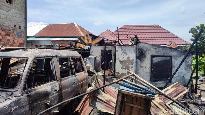 Rumah dan mobil milik Rozali yang terbakar di Palembang.