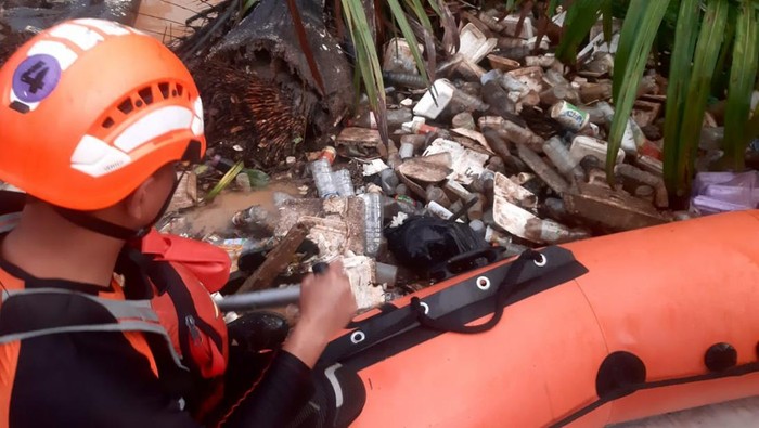 Tim SAR saat mencari balita terbawa arus selokan akibat banjir.