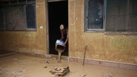 Warga membersihkan rumah mereka dari lumpur sisa banjir di Cobija, Bolivia, Minggu (3/3/2024).