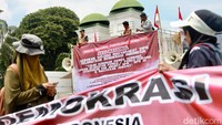 Massa membawa spanduk berisi tuntutan. 