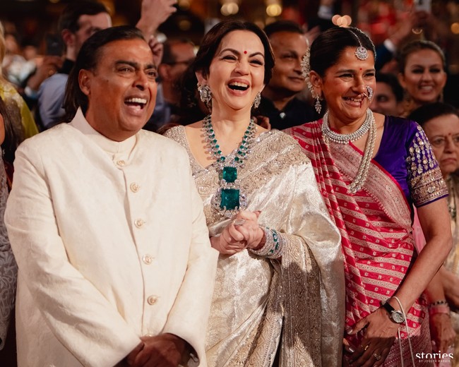 Aura bahagia terpancar dari wajah Mukesh Ambani dan istrinya Nita Ambani, juga ibu dari Radhika Merchant saat melihatnya berjalan memasuki podium. Lantunan lagu Shava Shava dari film Kabhi Khushi Kabhie Ghum mengiringi langkahnya. Foto: Instagram