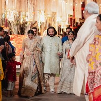 Saat memasuki podium, calon mempelai pria Anant Ambani terlihat gagah memakai sherwani berwarna putih gading. Putra bungsu Mukesh Ambani itu digandeng kakak perempuannya Isha Ambani dan istri dari abangnya Akash, Shloka Ambani. Foto: Instagram