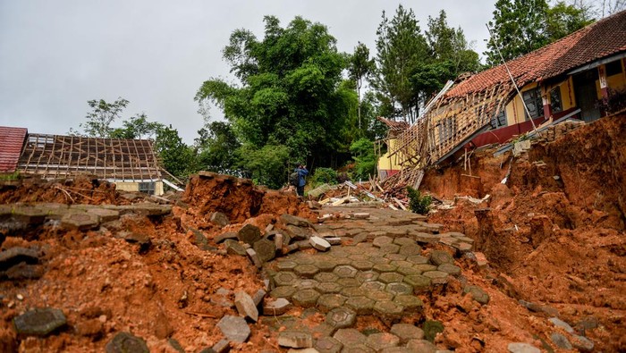 Penampakan 'Kampung Mati' di Bandung Barat Akibat Tanah Bergerak Seorang pewarta foto melintas di samping bangunan sekolah yang rusak dampak pergerakan tanah di Desa Cibedug, Kecamatan Rongga, Kabupaten Bandung Barat, Jawa Barat, Selasa (5/3/2024). Pusat Vulkanologi dan Mitigasi Bencana Geologi (PVMBG) memprediksi pergerakan tanah yang menghancurkan 10 rumah dan 192 kk mengungsi tersebut tidak akan meluas karena sudah terlokalisir dengan batas rekahan tanah yang berbentuk tapal kuda. ANTARA FOTO/Raisan Al Farisi/aww.