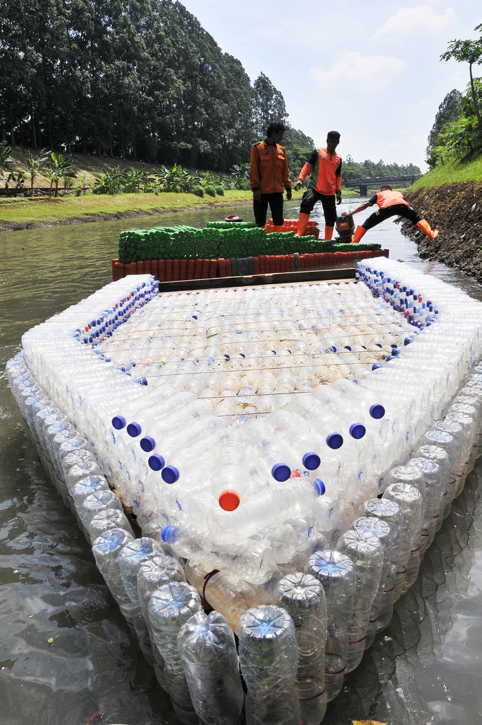 Perahu berbahan sampah botol plastik Sejumlah petugas Unit Penanganan Sampah Badan Air Dinas Lingkungan Hidup mengangkat perahu berbahan botol plastik bekas di Duren Sawit, Jakarta Timur, Selasa (5/3/2024). Menurut petugas UPS Badan Air sebanyak 1.000 botol plastik dimanfaatkan untuk pembuatan perahu selama dua minggu yang bisa membawa enam orang saat melakukan pembersihan sampah di aliran Kanal Banjir Timur. ANTARA FOTO/ Fakhri Hermansyah/aww.