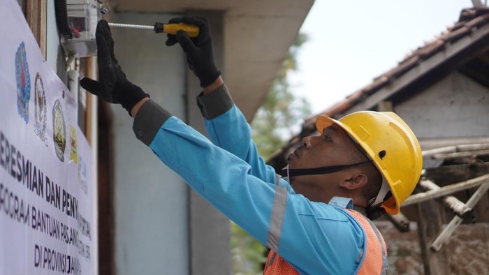 Petugas PLN tengah memeriksa meteran listrik.