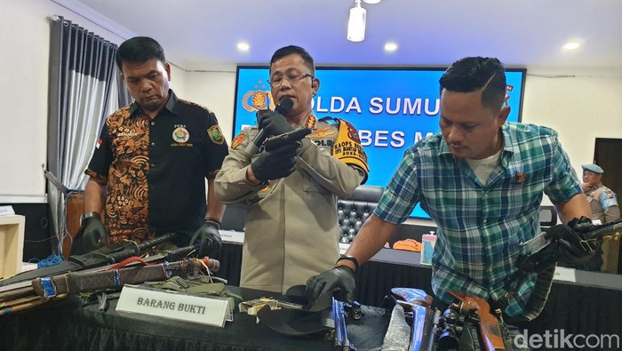 Polisi menunjukkan barang bukti senjata api yang dibawa anggota ormas PKN