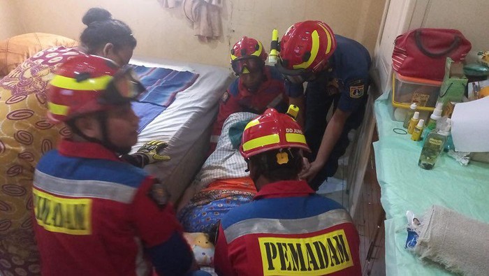 Damkar Cempaka Putih Jakpus membantu warga sakit yang kesulitan naik ke tempat tidur. (dok Dinas Gulkarmat DKI)