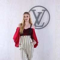 Sophie Terner muncul dalam balutan jumpsuit denggan aksentuasi pada bagian lengan. (Foto: Pascal Le Segretain/Getty Images for Louis Vuitton)