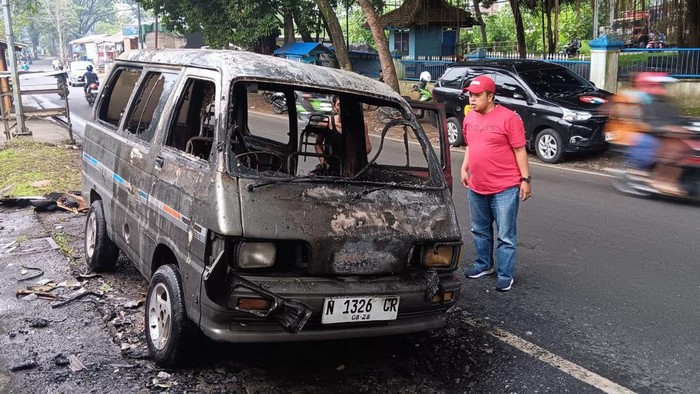 PMK tengah melakukan pendinginan mobil Daihatsu Zebra yang terbakar di Kota Malang.