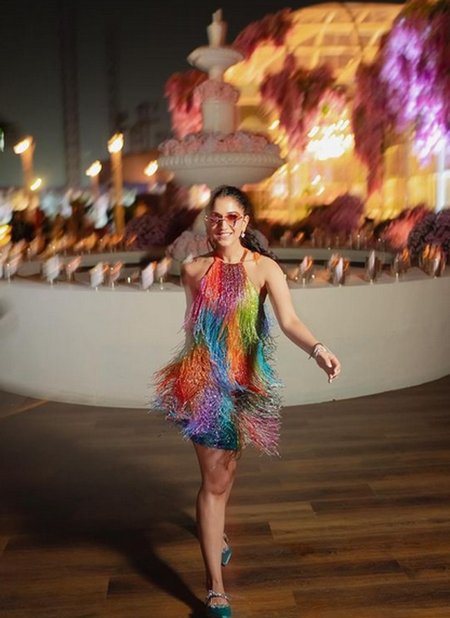 Acara malam hari, Radhika tampil colorful dengan gaun strapless manik-manik. Mengambil inspirasi dari budaya disko, penampilan Radhia tersebut memancarkan vibe glamor retro. Kacamata berwarna berbentuk hati dari Cartier menambahkan sentuhan ceria namun anggun pada penampilannya. Foto: dok. Instagram @ sangeetahairartist