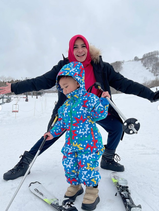 Rayyanza atau yang biasa dipanggil Cipung itu tampil mengenakan setelan jaket musim dingin berwarna biru yang ramai dipenuhi motif berwarna-warni. Seperti biasa, penampilan Rayyanza pun selalu berhasil mencuri atensi. Foto: Instagram/@rieta_amilia