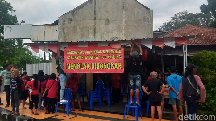 Warga mendatangi balai RW dan memasang spanduk.
