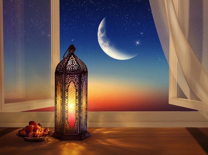 Ramadan lantern by the open window. Beautiful Greeting Card with copy space for Ramadan and Muslim Holidays. An illuminated Arabic lamp. Mixed media.