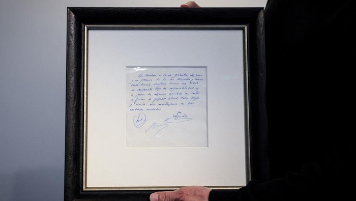 A guest looks at a napkin, written on by Barcelonas Sporting Director at that time Carles Rexach on December 14, 2000, promising a contract to secure 13-year-old Lionel Messi for FC Barcelona, on display at Bonhams Auctions in New York City, U.S., March 6, 2024.  REUTERS/Brendan McDermid