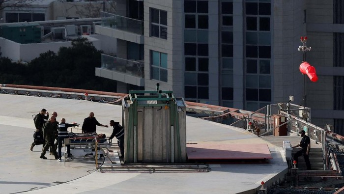 A patient is carried on a hospital bed after being transported on an Israeli military helicopter at the helipad of a hospital, amid the ongoing conflict between Israel and Hamas in Gaza, in Tel Aviv, Israel March 6, 2024. REUTERS/Carlos Garcia Rawlins