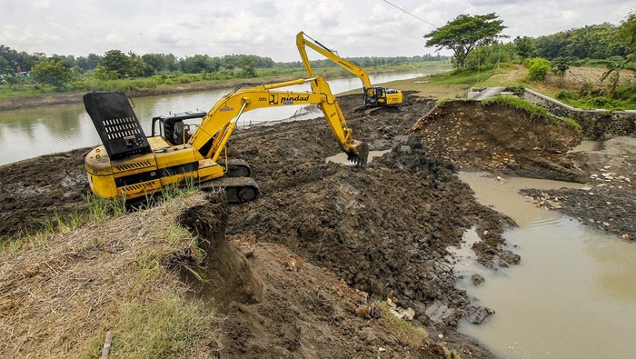 Pekerja mengoperasikan alat berat memperbaikiu tanggul waduk yang jebol di Padangan, Bojonegoro, Jawa Timur, Kamis (7/3/2024). Pemerintah setempat mempercepat upoaya perbaikan tanggul yang rusak guna mengantisipasi  terjadinya banjir susulan setelah terjadinya banjir pada Rabu (6/3) akibat tanggul jebol. ANTARA FOTO/Muhammad Mada/tom.