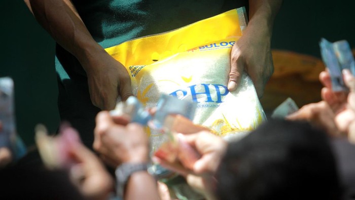 Warga berebutan membeli beras Bulog pada Gerakan Pangan Murah (GPM) di Lapangan Taruna Remaja, Kota Gorontalo, Gorontalo, Kamis (7/3/2024). Pemerintah Kota Gorontalo bersama Bulog Cabang Gorontalo dan distributor pangan menjual bahan kebutuhan pokok seperti beras, minyak goreng, telur ayam, ikan dan bahan kebutuhan lainnya dengan harga di bawah pasaran menjelang bulan Ramadhan. ANTARA FOTO/Adiwinata Solihin/rwa.