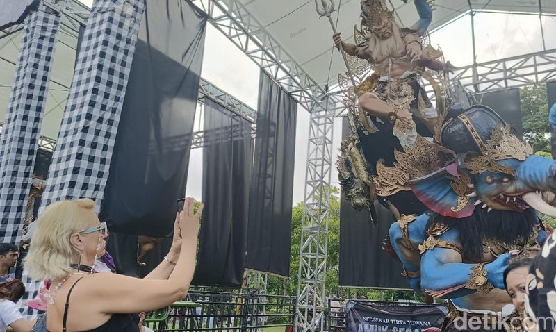 Seorang turis asing memotret salah satu ogoh-ogoh yang dipamerkan dalam Kasanga Fest 2024 di Lapangan Puputan Badung I Gusti Ngurah Made Agung Denpasar, Sabtu (2/3/2024).