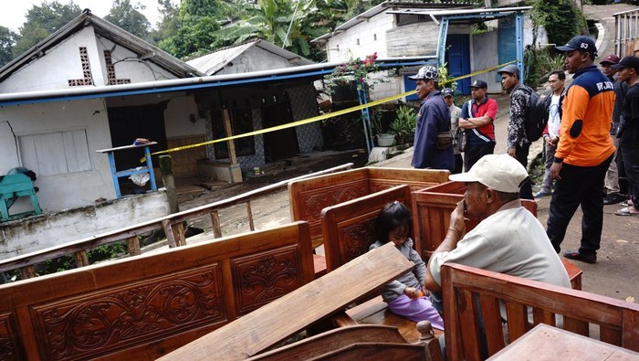 Warga berjalan melintasi rumah rusak akibat bencana tanah bergerak di Dusun Sumberlamong, Desa Sambirejo, Kecamatan Wonosalam, Kabupaten Jombang, Jawa Timur, Kamis (7/3/2024). Pergerakan tanah yang terjadi pada Rabu (6/3/2024) tengah malam saat hujan deras itu mengakibatkan 12 rumah dan fasilitas umum rusak, akses jalan terputus dan puluhan warga terdampak mengungsi ke tempat yang aman. ANTARA FOTO/Syaiful Arif/rwa.