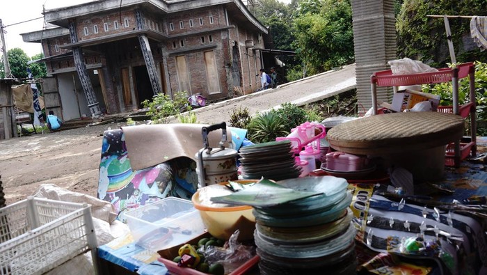 Warga berjalan melintasi rumah rusak akibat bencana tanah bergerak di Dusun Sumberlamong, Desa Sambirejo, Kecamatan Wonosalam, Kabupaten Jombang, Jawa Timur, Kamis (7/3/2024). Pergerakan tanah yang terjadi pada Rabu (6/3/2024) tengah malam saat hujan deras itu mengakibatkan 12 rumah dan fasilitas umum rusak, akses jalan terputus dan puluhan warga terdampak mengungsi ke tempat yang aman. ANTARA FOTO/Syaiful Arif/rwa.