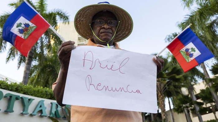Warga Puerto Rico Ikut Demo Tuntut PM Haiti Mengundurkan Diri Protesters holding Haitian national flags and handmade signs with messages demanding Haiti's Prime Minister Ariel Henry resign, gather outside of the Marriott Hotel where they believe Henry is staying, in San Juan, Puerto Rico, Wednesday, March 6, 2024. Haitian politicians started pursuing new alliances Wednesday, seeking a coalition that could lead the country out of the gang violence that has fueled lawlessness, closed the main airport and prevented Henry from returning home. (AP Photo/Alejandro Granadillo)