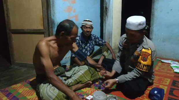 Aiptu Dedi Suardi saat memeriksa warga yang sakit di Wolya Barat, Aceh Barat.