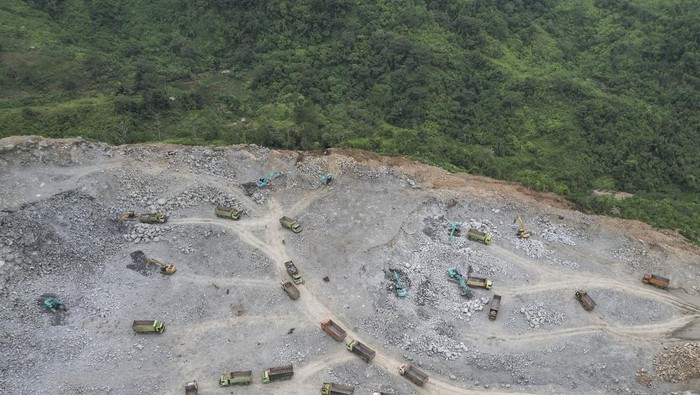 Foto udara pekerja menggunakan alat berat mengangkut material batu andesit untuk pembangunan Bendungan Leuwikeris di Gunung Pangajar, Kabupaten Tasikmalaya, Jawa Barat, Kamis (7/3/2024). Kementerian PUPR terus mendorong optimalisasi pemanfaatan waduk atau bendungan multiguna untuk mencapai target Energi Baru Terbarukan (EBT) sebesar 23 persen pada tahun 2025 menuju zero emission pada tahun 2060. ANTARA FOTO/Adeng Bustomi/YU